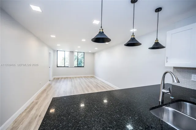 a view of a kitchen sink and a wooden floor