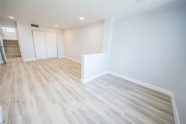 a view of an empty room with wooden floor