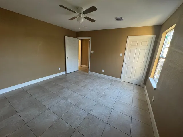 a view of a livingroom with a ceiling fan and window