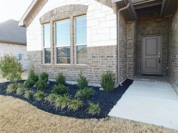 a view of a brick house with potted plants