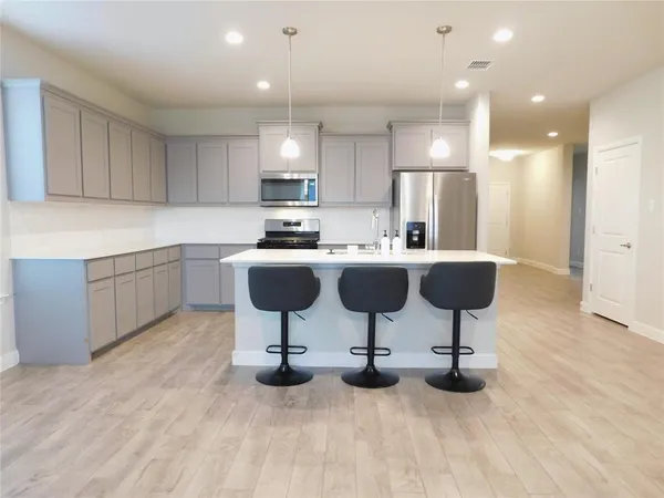 a kitchen with a sink a cabinets and chairs