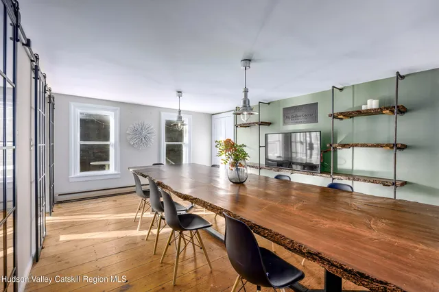 a dining room with a table chairs and a floor to ceiling window