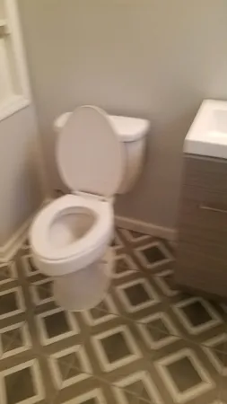 a view of a hallway with wooden floor and a bathroom