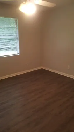 a view of a small space with wooden floor and a window