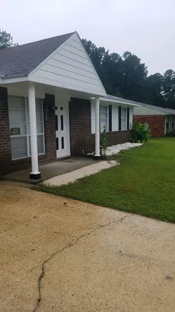 a front view of a house with a yard and potted plants