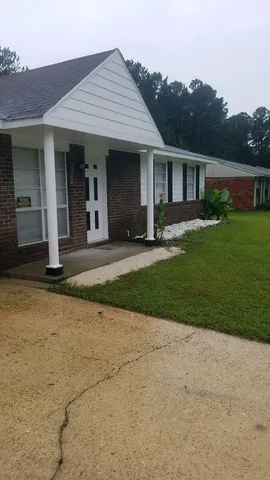 a front view of a house with a yard and potted plants
