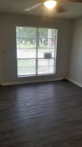 a view of a room with wooden floor and a window