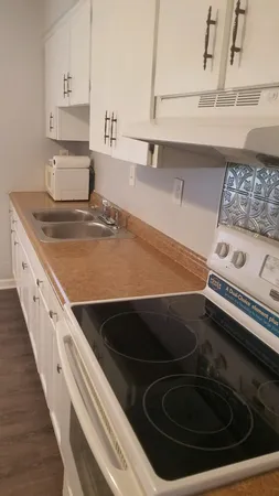 a kitchen with granite countertop white cabinets and white appliances