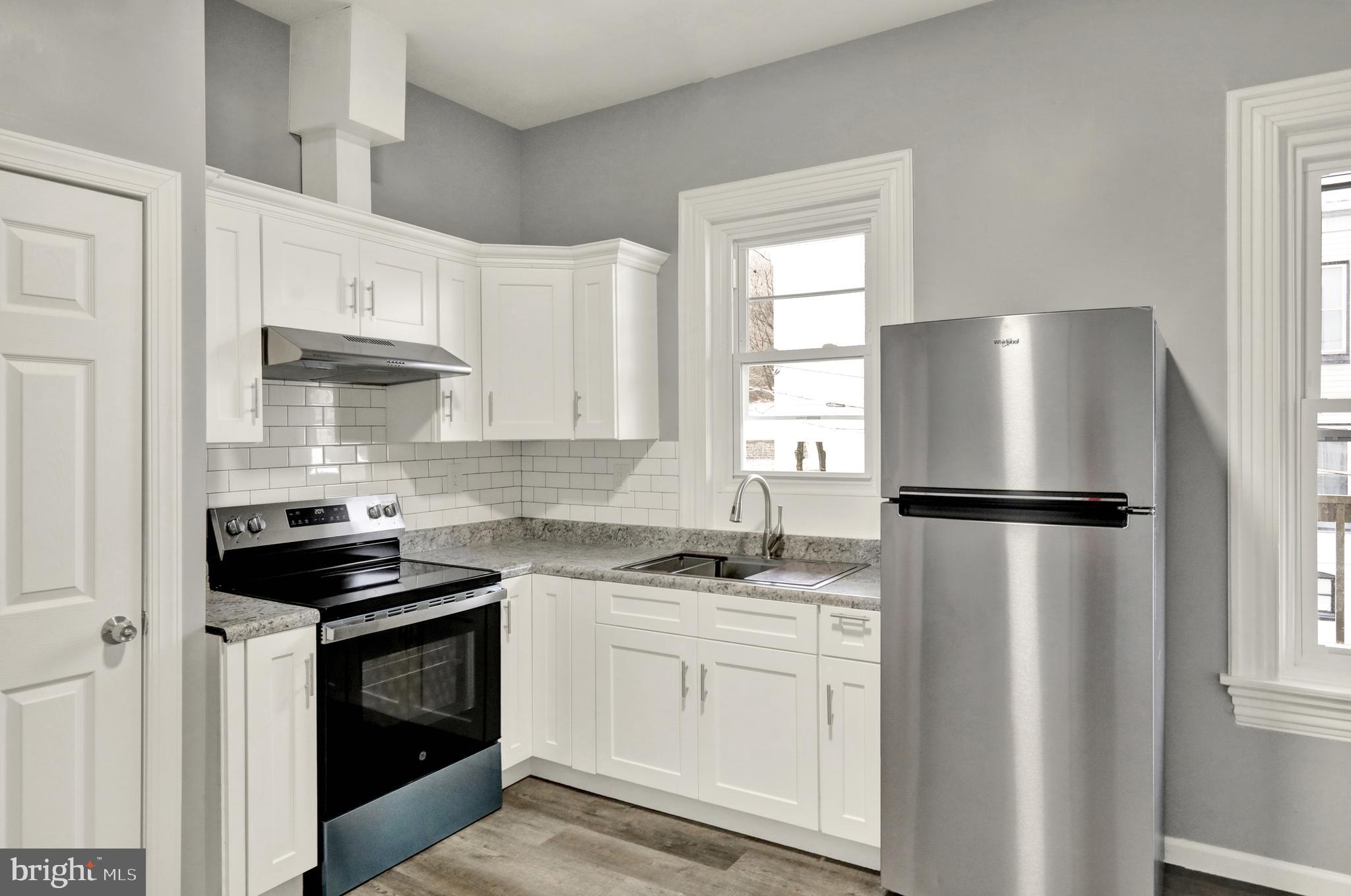 1156 Franklin Street, Unit 3 Reading, PA 19602 - Photo 2 of 11 a kitchen with a stove a refrigerator and a window
