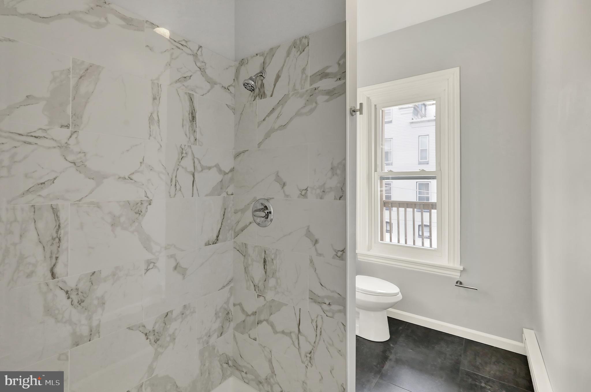 1156 Franklin Street, Unit 3 Reading, PA 19602 - Photo 4 of 11 a bathroom with a toilet sink a window and vanity