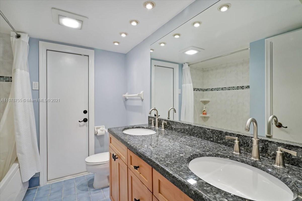 1525 Southwest 6th Avenue Boca Raton, FL 33486 - Photo 15 of 30 a bathroom with a granite countertop sink a toilet a large mirror and shower