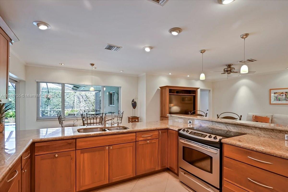 1525 Southwest 6th Avenue Boca Raton, FL 33486 - Photo 4 of 30 a kitchen with stainless steel appliances granite countertop a stove a sink and a granite counter tops with wooden floors