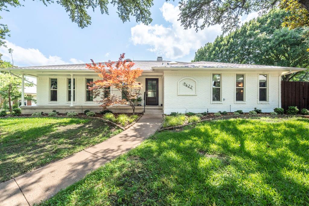 a front view of house with yard and trees around