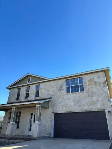 a view of a big house with wooden fence