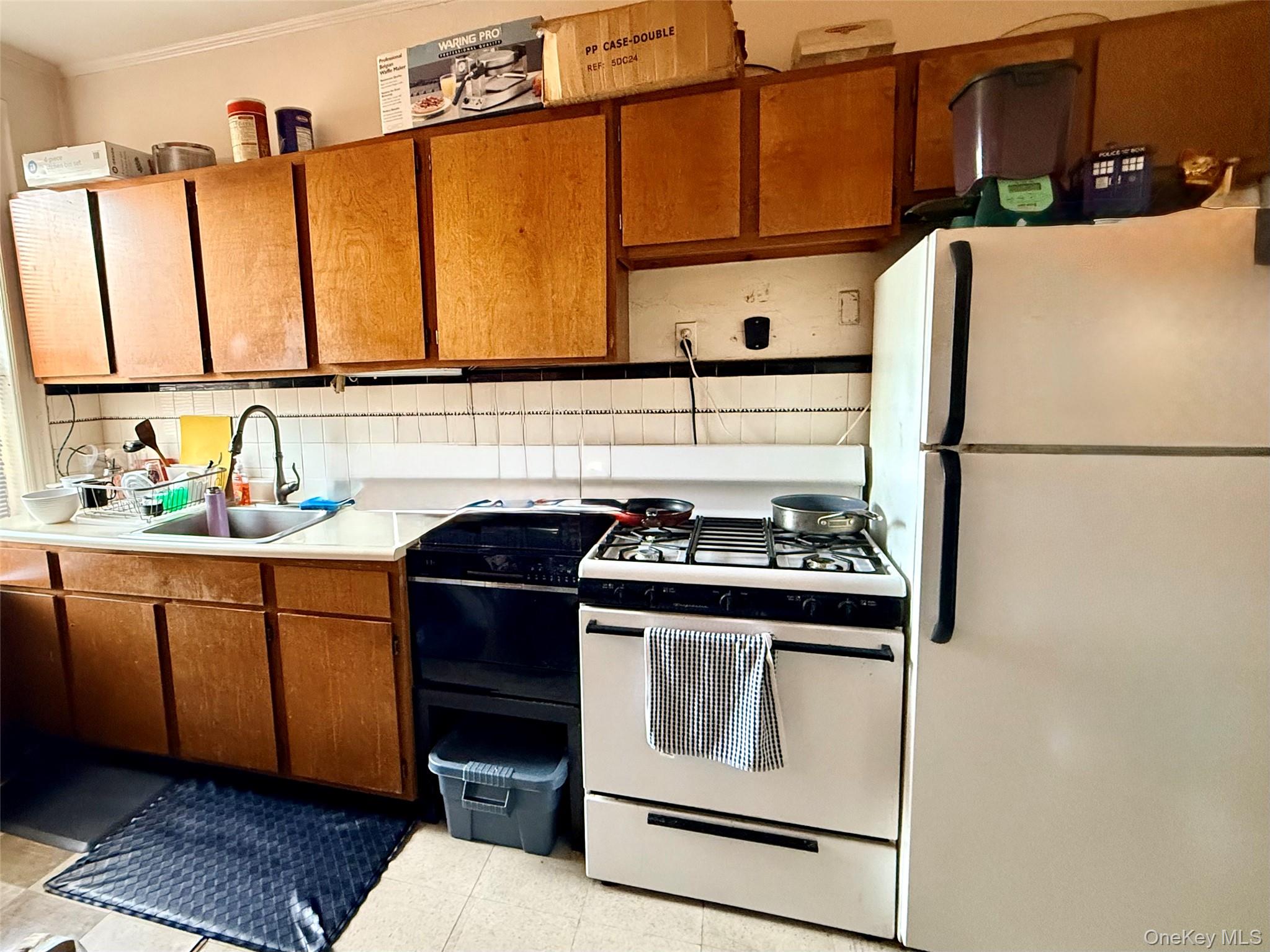 19-01 21st Road Queens, NY 11105 - Photo 8 of 8 a kitchen with stainless steel appliances granite countertop a sink stove and refrigerator