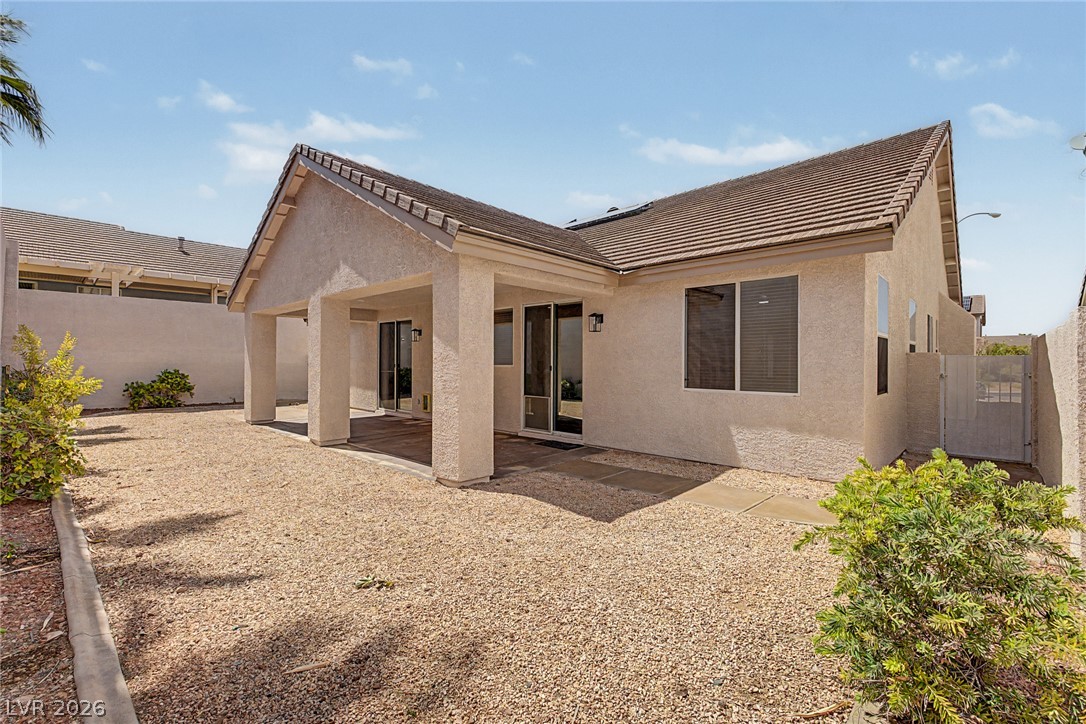 835 Entrada Ridge Avenue Henderson, NV 89012 - Photo 33 of 34 A covered patio extends from this stucco residence, set within a drought-tolerant yard.
