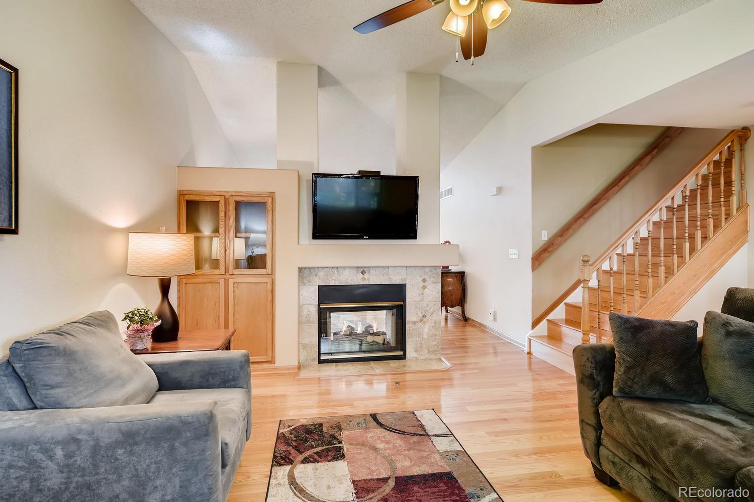 9840 South Castle Ridge Circle Highlands Ranch, CO 80129 - Photo 11 of 28 a living room with furniture a fireplace and a flat screen tv