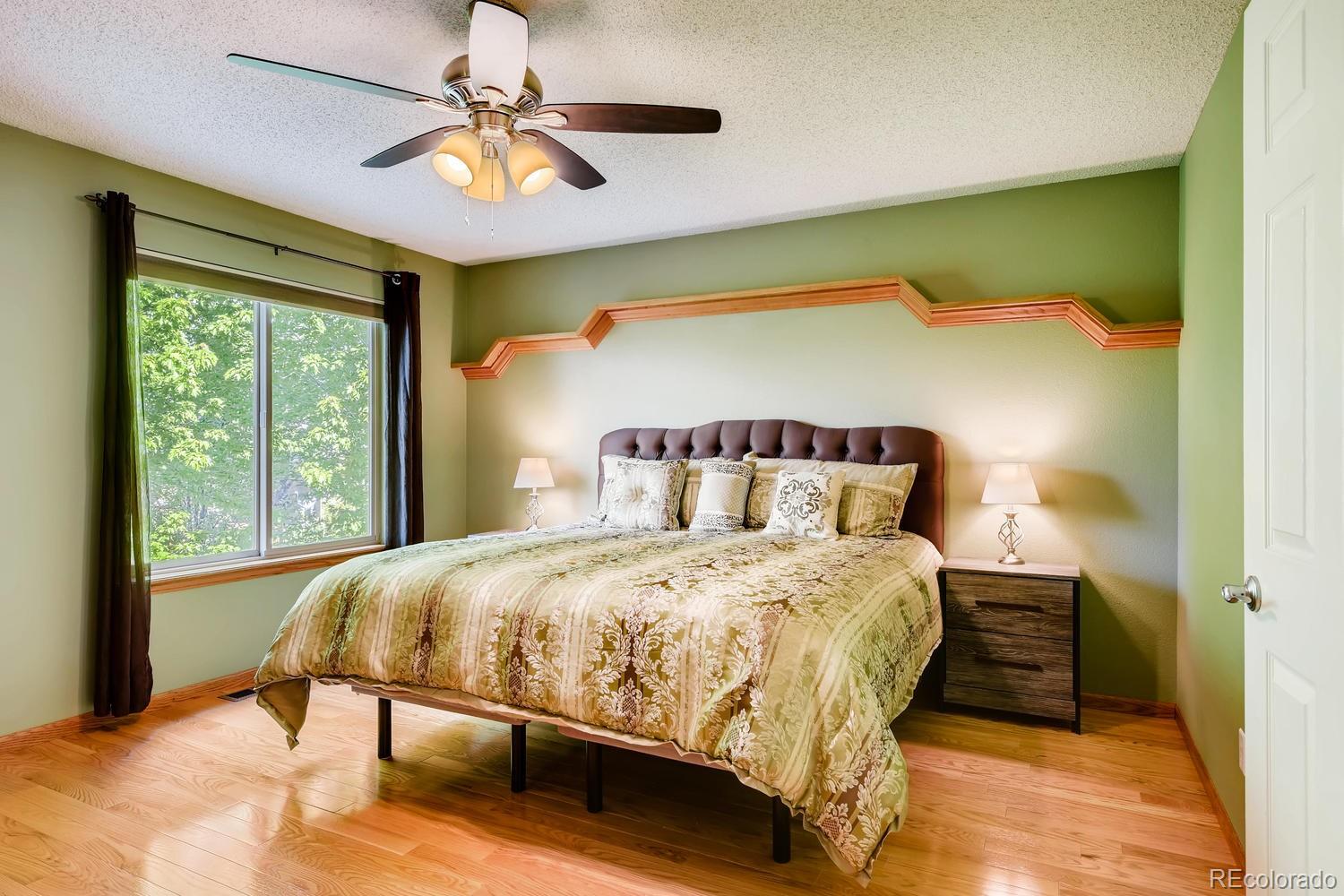 9840 South Castle Ridge Circle Highlands Ranch, CO 80129 - Photo 13 of 28 a bedroom with a bed and a chandelier