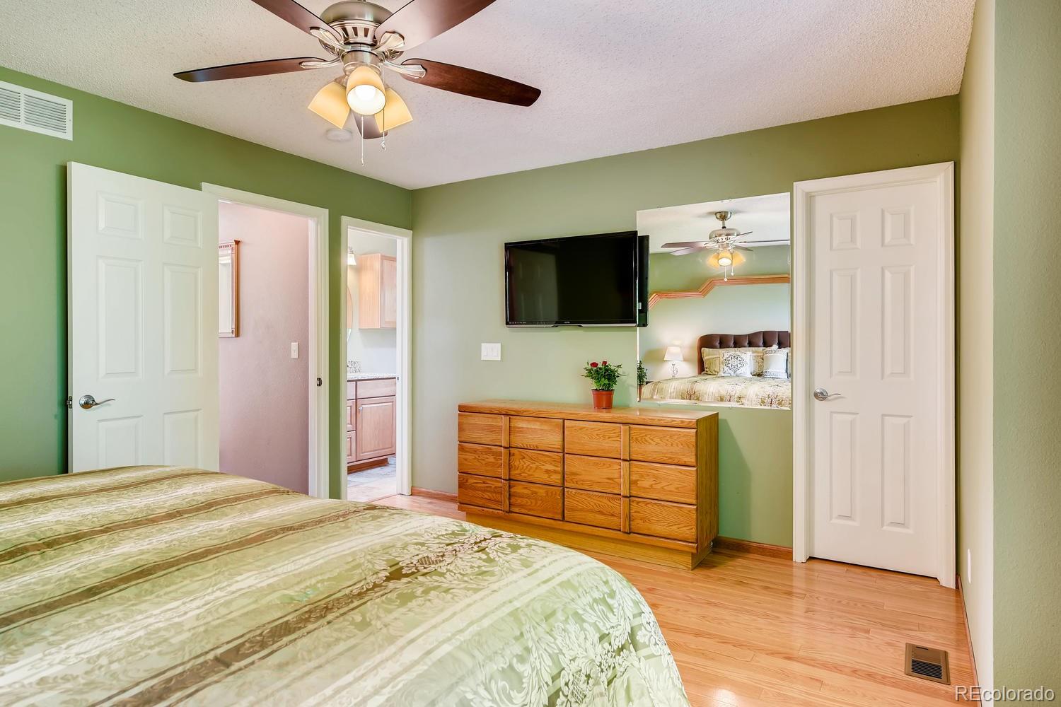 9840 South Castle Ridge Circle Highlands Ranch, CO 80129 - Photo 14 of 28 a bedroom with a bed and a flat screen tv