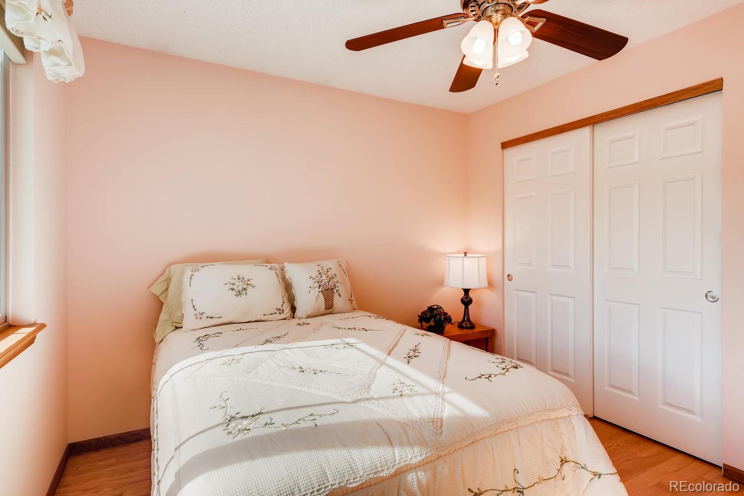 9840 South Castle Ridge Circle Highlands Ranch, CO 80129 - Photo 17 of 28 a bedroom with a bed and a chandelier