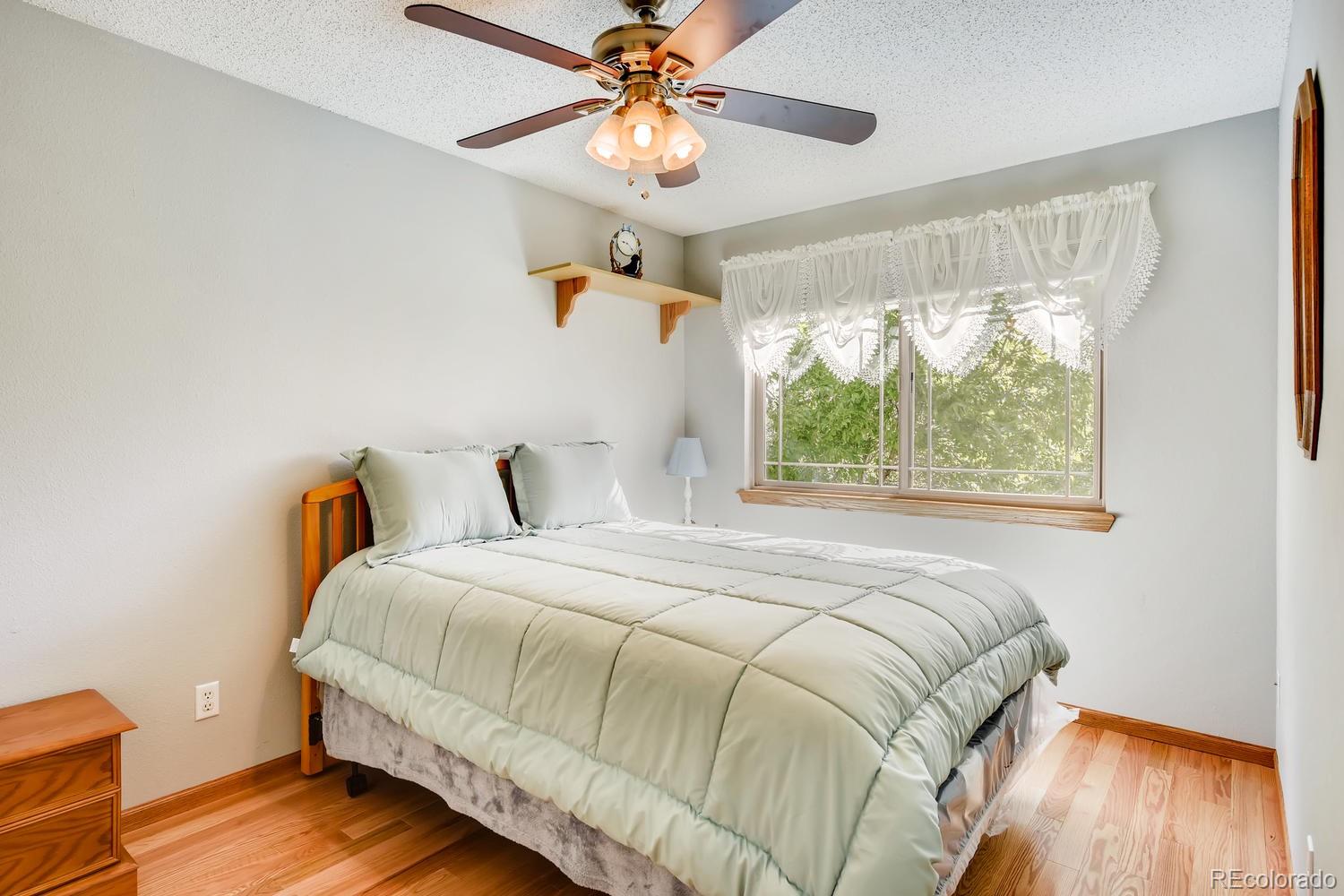 9840 South Castle Ridge Circle Highlands Ranch, CO 80129 - Photo 18 of 28 a bedroom with a bed and a chandelier