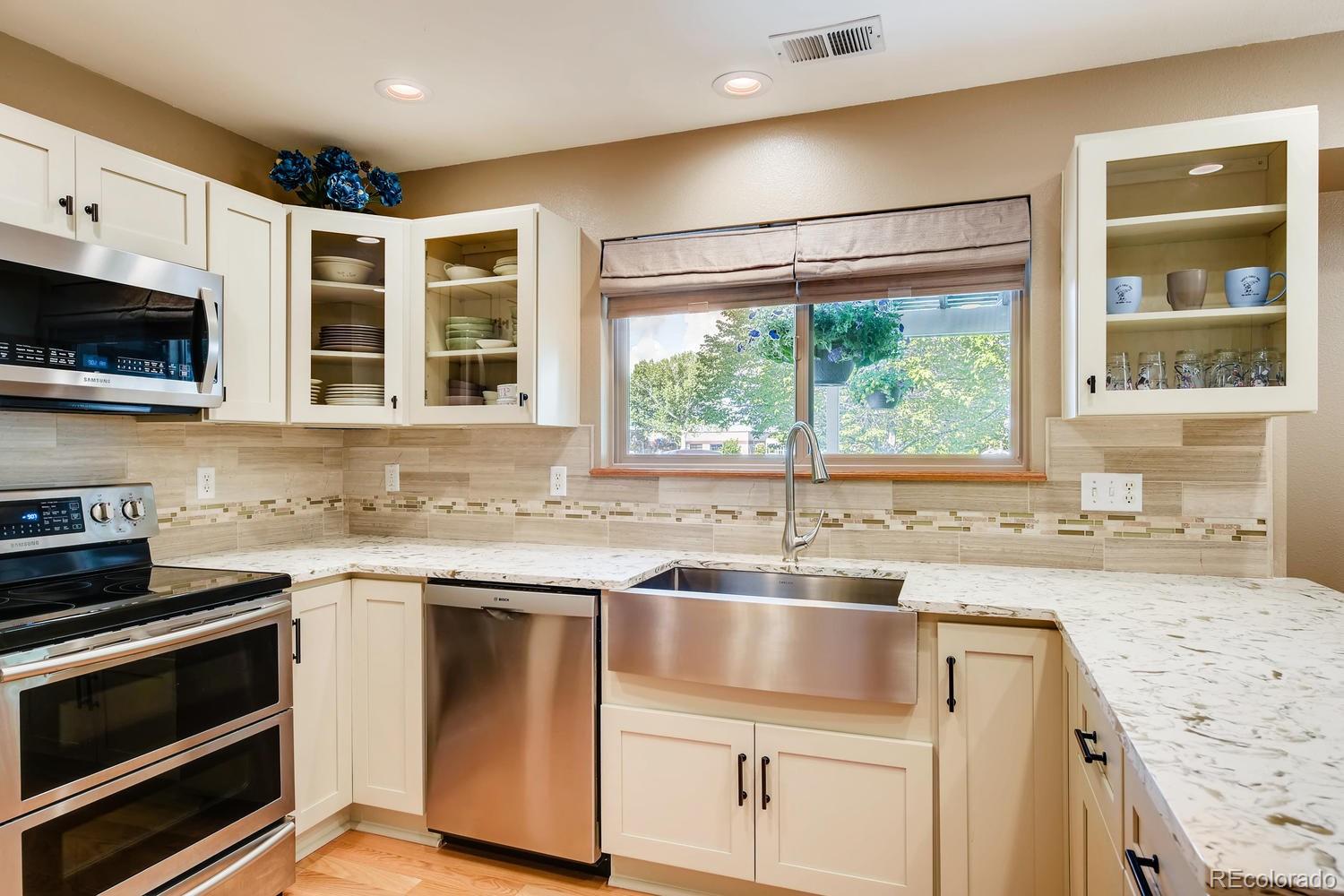 9840 South Castle Ridge Circle Highlands Ranch, CO 80129 - Photo 6 of 28 a kitchen with granite countertop a sink stainless steel appliances and cabinets