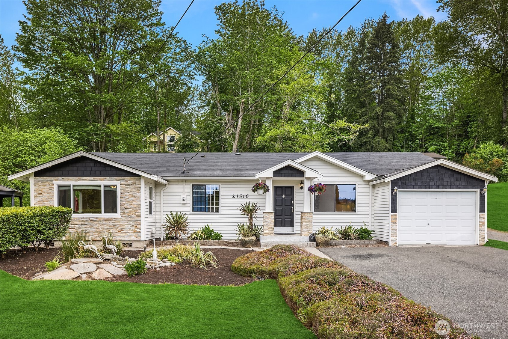 a front view of a house with a garden and trees
