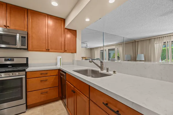 a kitchen with stainless steel appliances granite countertop a sink and a stove