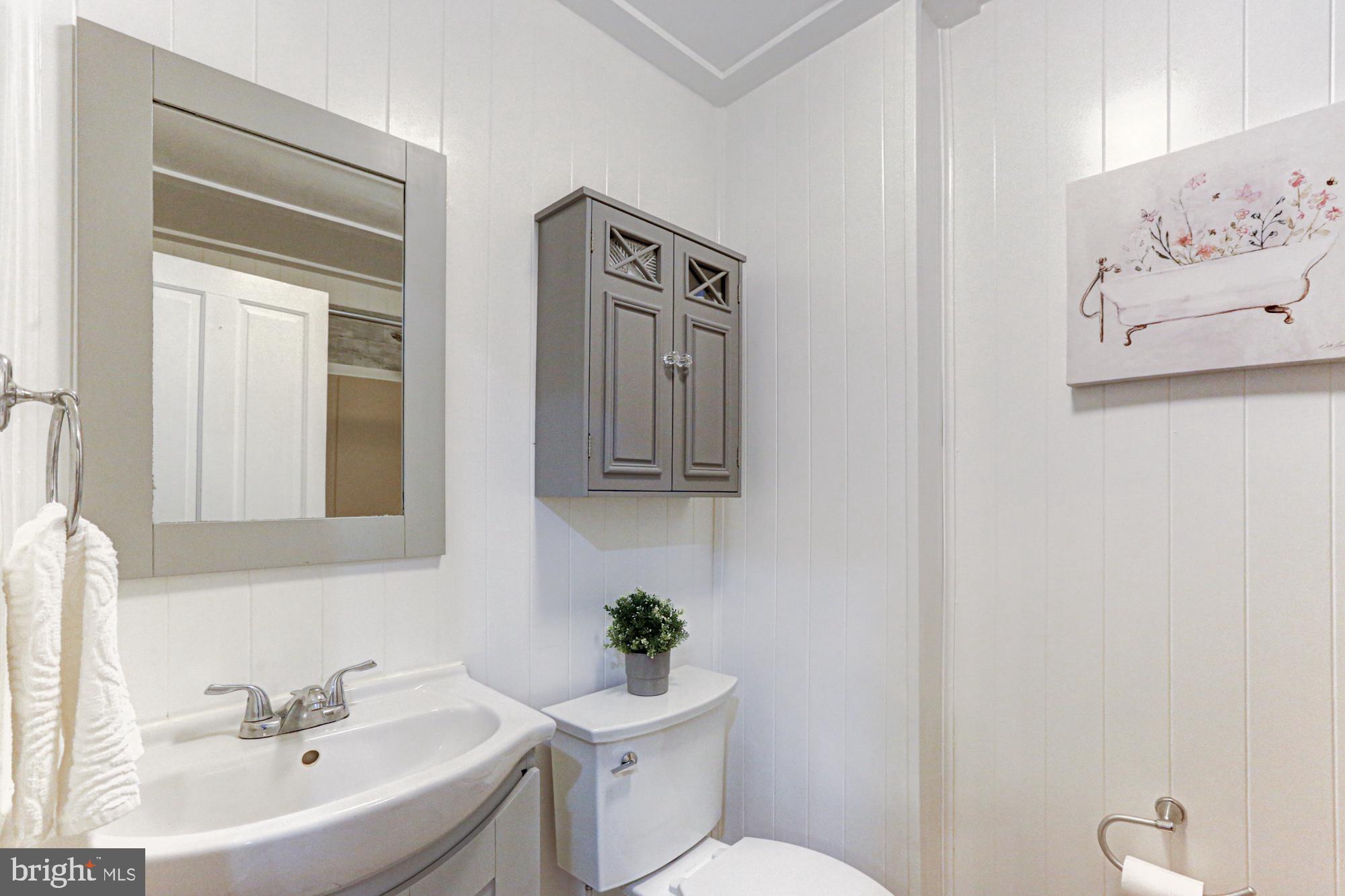 421 Main Street Clayton, DE 19938 - Photo 35 of 77 a bathroom with a toilet a sink and mirror
