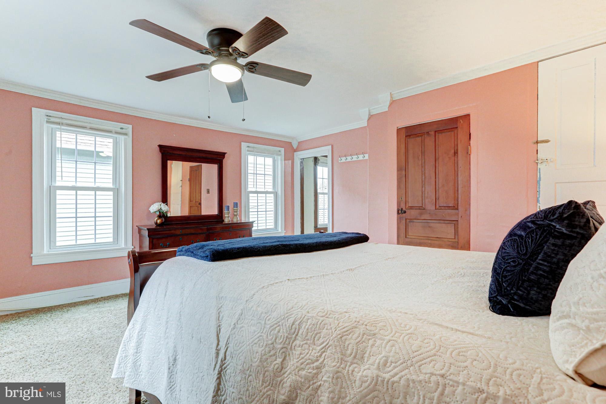 421 Main Street Clayton, DE 19938 - Photo 48 of 77 a bedroom with a bed next to a window with a chandelier