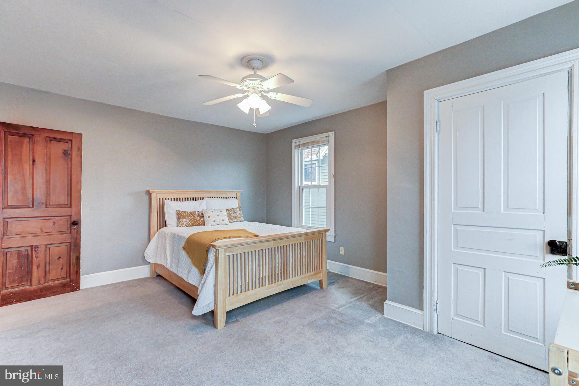 421 Main Street Clayton, DE 19938 - Photo 58 of 77 a spacious bedroom with a bed and a chandelier