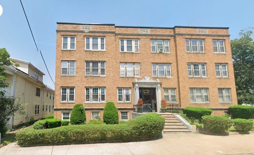 a front view of a residential apartment building with a yard