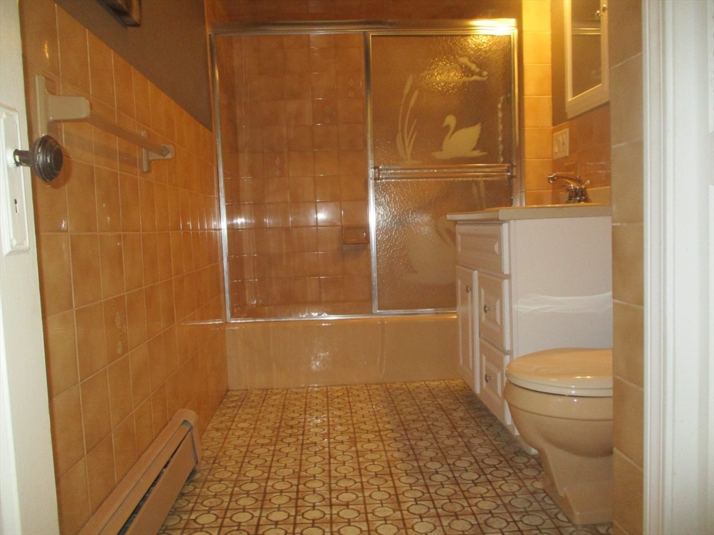 84 Tudor Street, Unit 4 Chelsea, MA 02150 - Photo 16 of 16 a bathroom with a granite countertop shower and a toilet