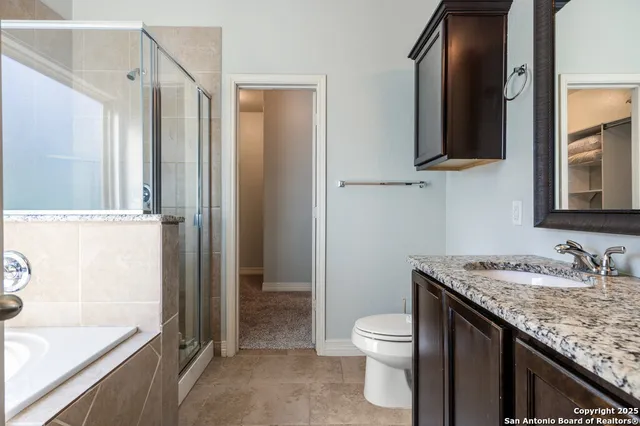 a bathroom with a granite countertop sink toilet and shower