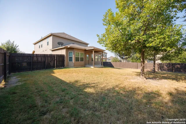 a view of a house with a yard and tree