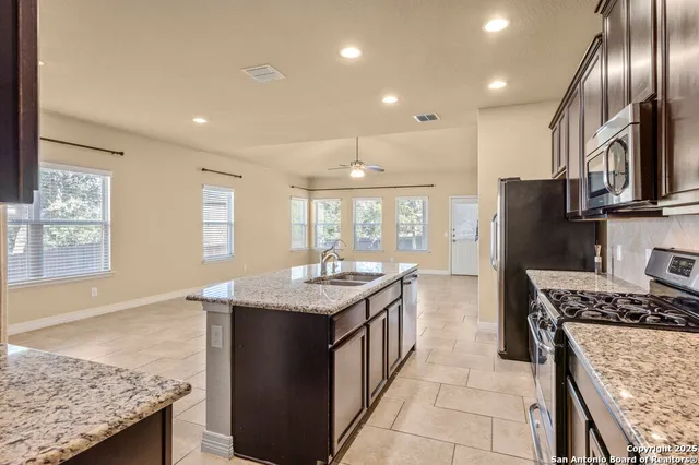 a kitchen with stainless steel appliances granite countertop a sink stove and refrigerator