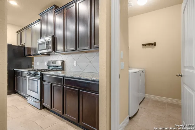 a kitchen with stainless steel appliances granite countertop a refrigerator and a stove