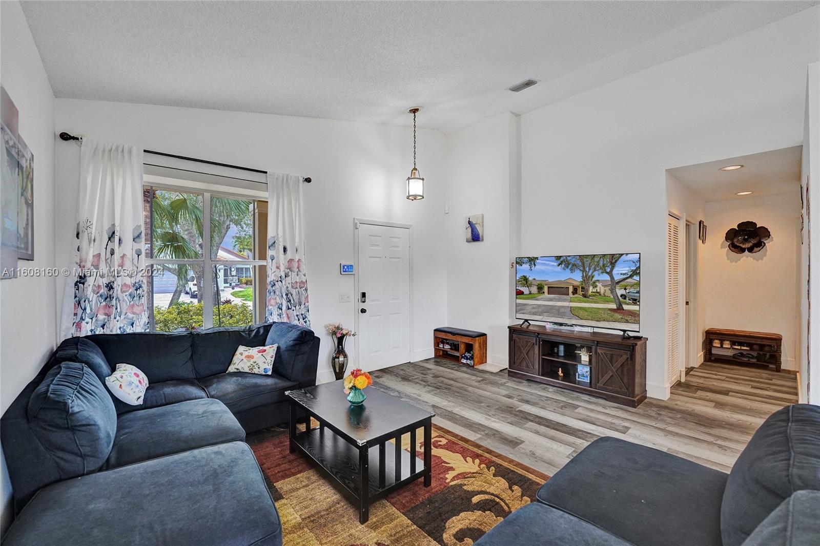 931 Falling Water Road Weston, FL 33326 - Photo 3 of 20 a living room with furniture fireplace and window