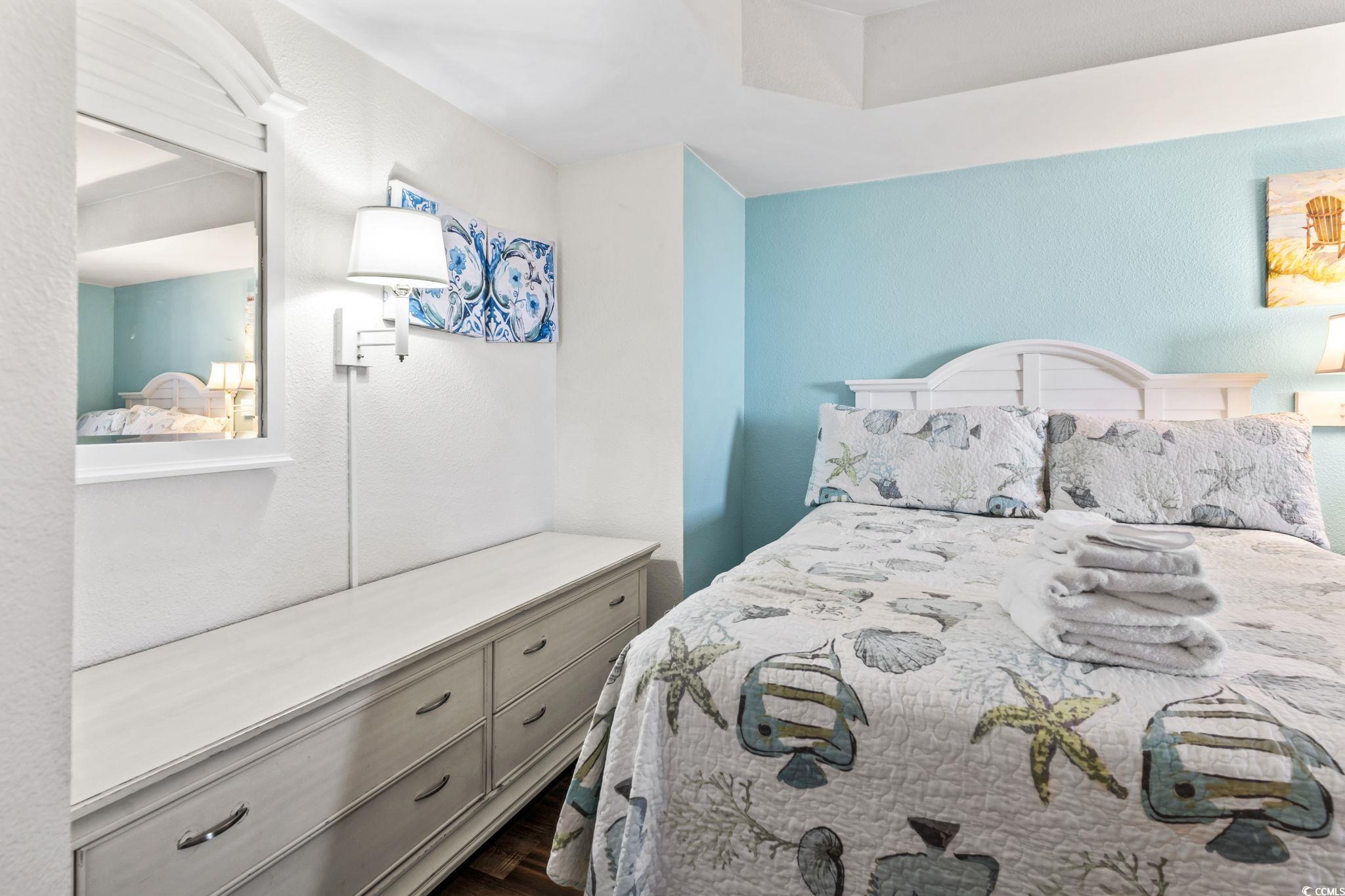 7100 North Ocean Boulevard, Unit 616 Myrtle Beach, SC 29572 - Photo 13 of 23 Bedroom with a textured wall and dark wood finished floors