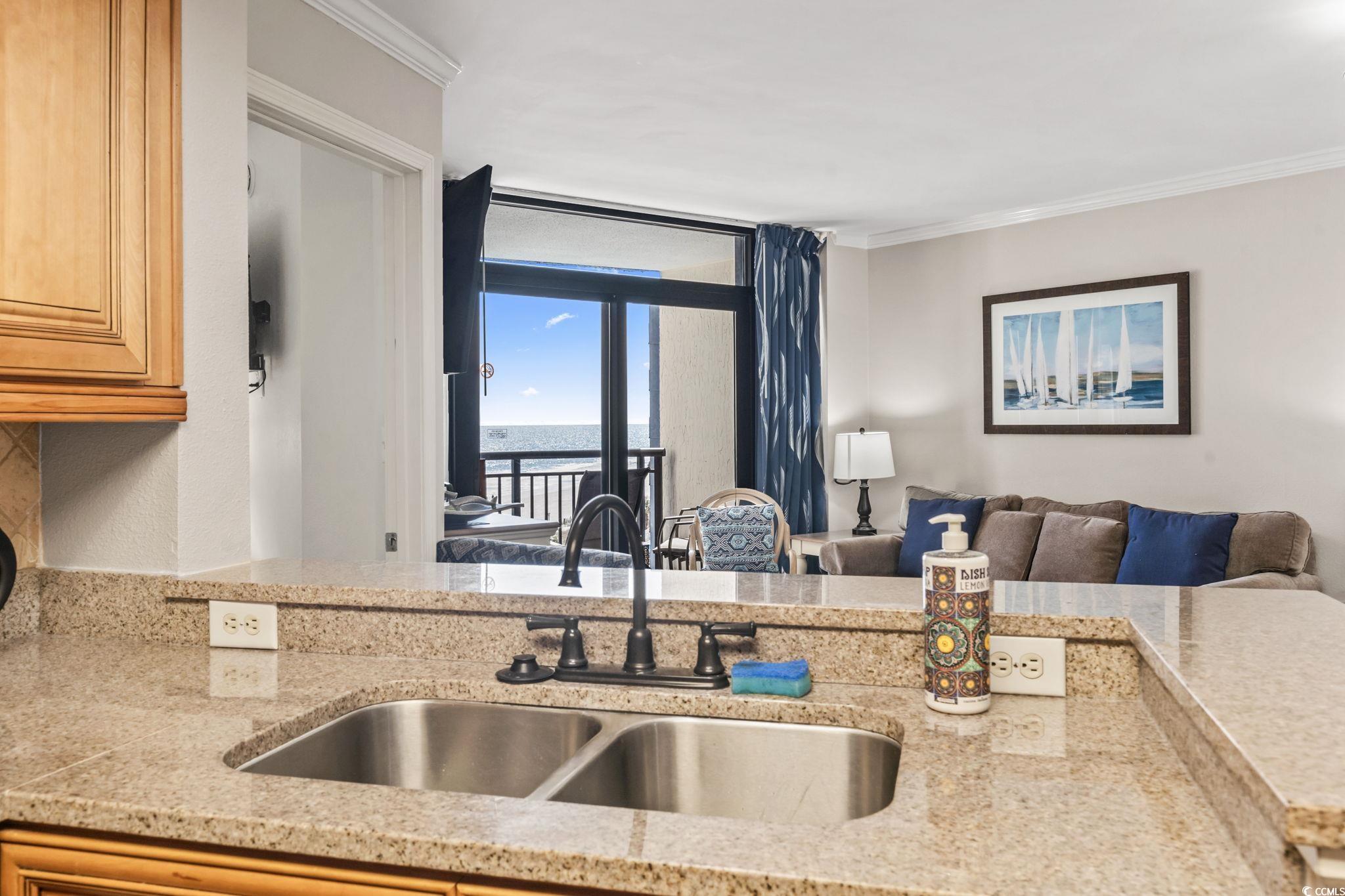 7100 North Ocean Boulevard, Unit 616 Myrtle Beach, SC 29572 - Photo 23 of 23 Kitchen featuring open floor plan, ornamental molding, a water view, and light stone counters