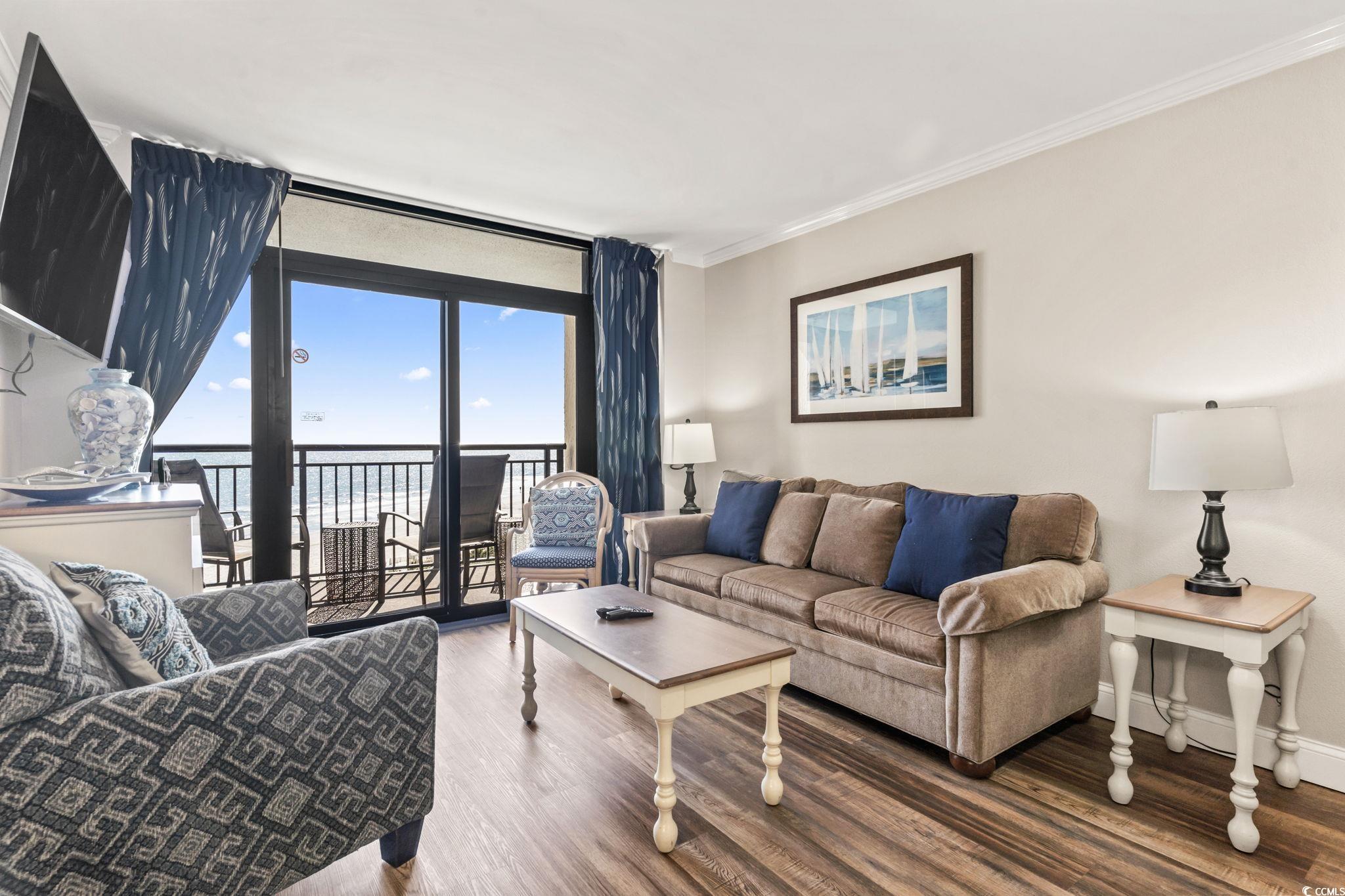 7100 North Ocean Boulevard, Unit 616 Myrtle Beach, SC 29572 - Photo 7 of 23 Living area featuring ornamental molding, wood finished floors, floor to ceiling windows, and a water view