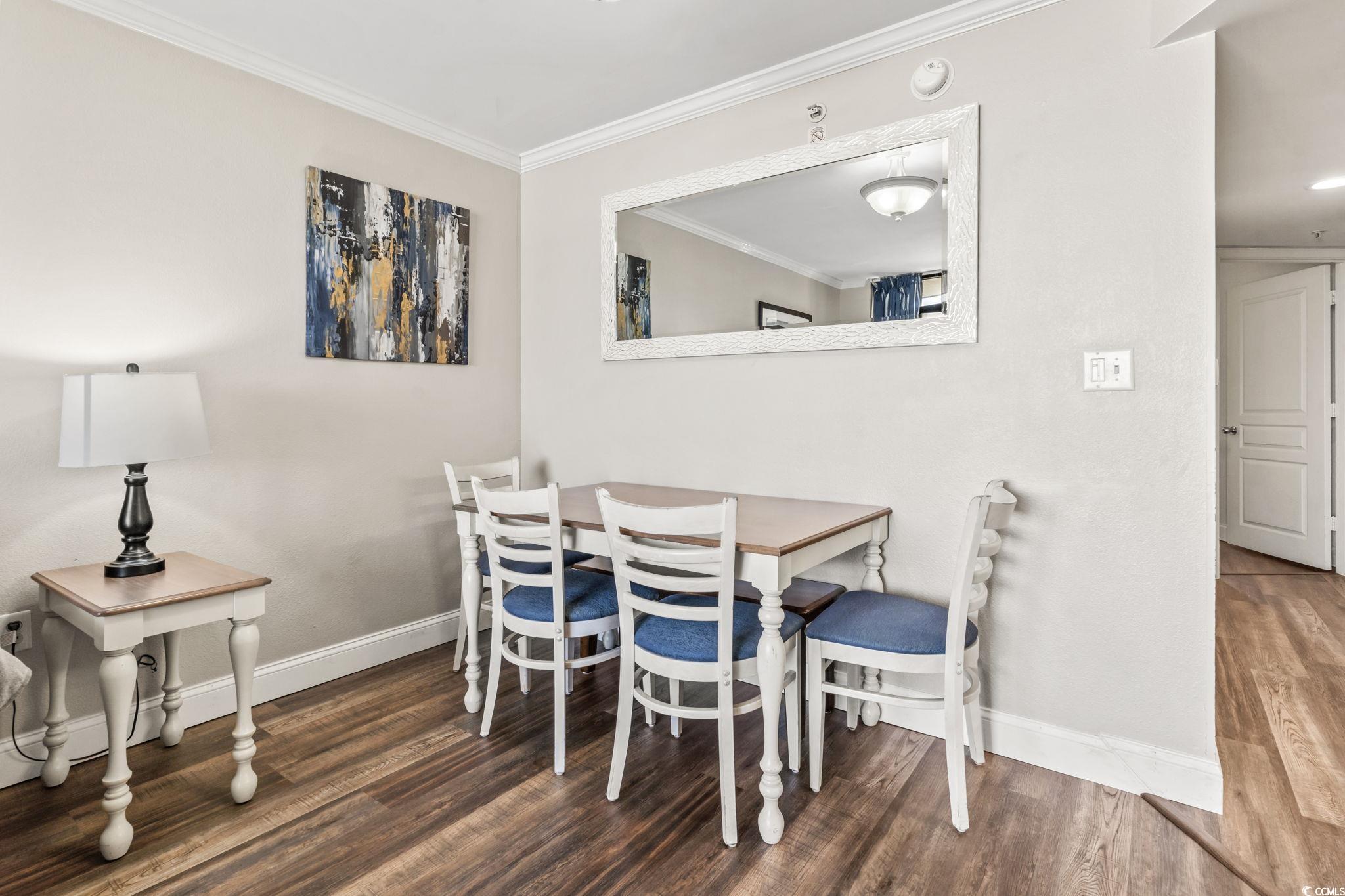 7100 North Ocean Boulevard, Unit 616 Myrtle Beach, SC 29572 - Photo 9 of 23 Dining space featuring crown molding and dark wood-style floors