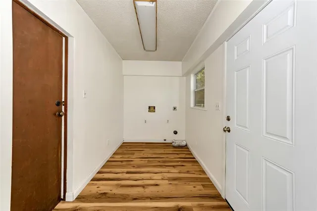 a view of a hallway with wooden floor and entryway