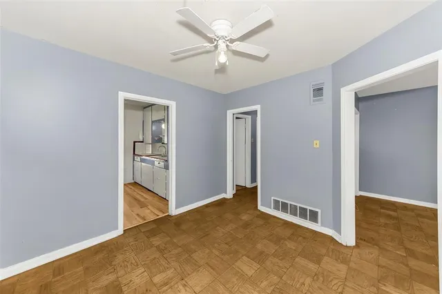 an empty room with closet and a ceiling fan
