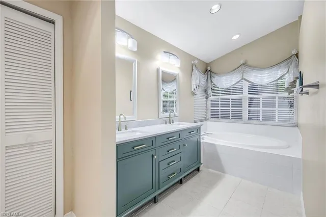 a bathroom with a granite countertop bathtub sink and mirror