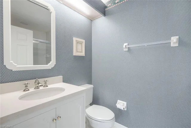 a bathroom with a sink a toilet and mirror
