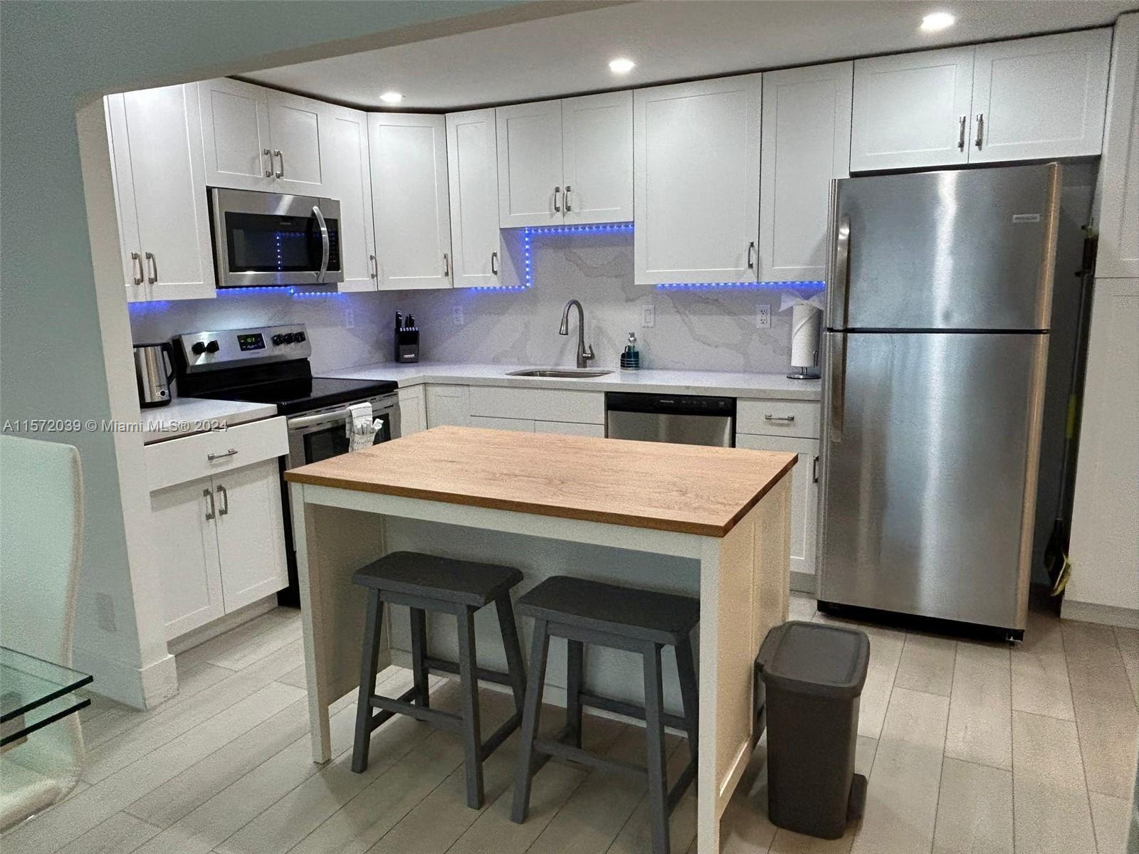a kitchen with stainless steel appliances a refrigerator stove microwave and cabinets