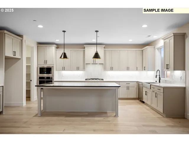 a large kitchen with kitchen island a sink stainless steel appliances and cabinets