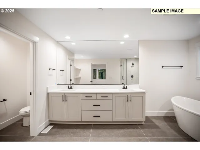 a spacious bathroom with a granite countertop sink a toilet a mirror and a bathtub
