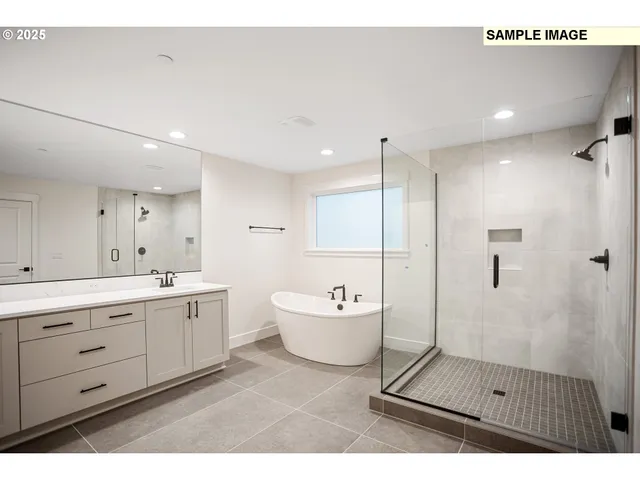 a spacious bathroom with a double vanity sink a mirror and a bathtub